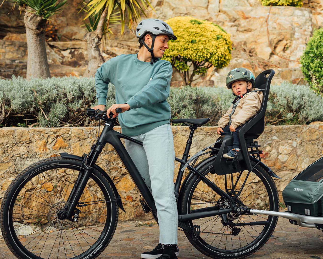 Vuxen som cyklar med barn i cykelstol