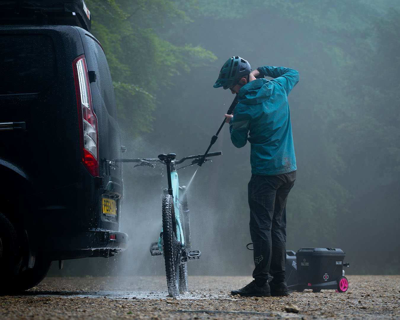 Person som spolar vatten på sin cykel