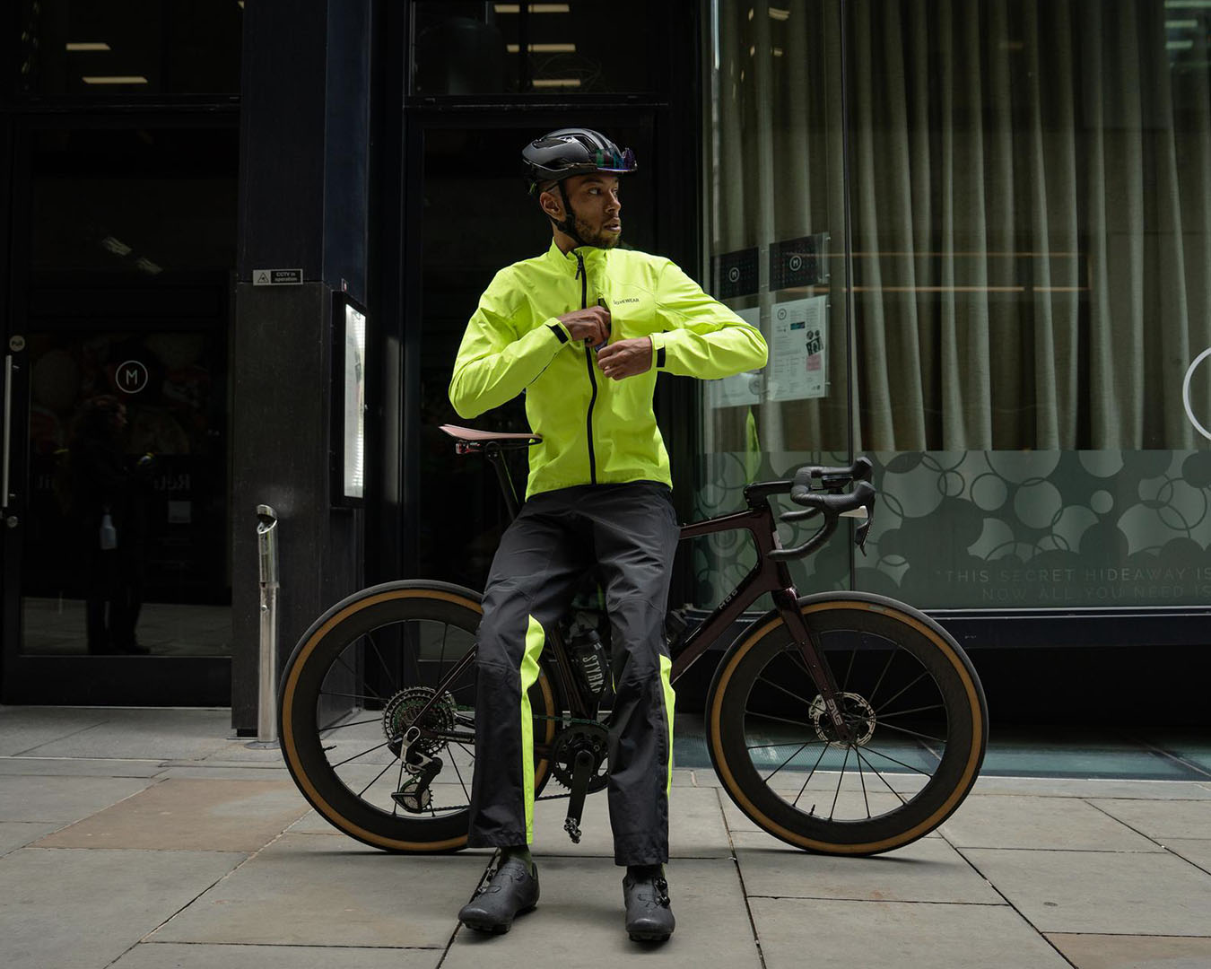 Man som drar upp dragkedjan på sin gula cykeljacka