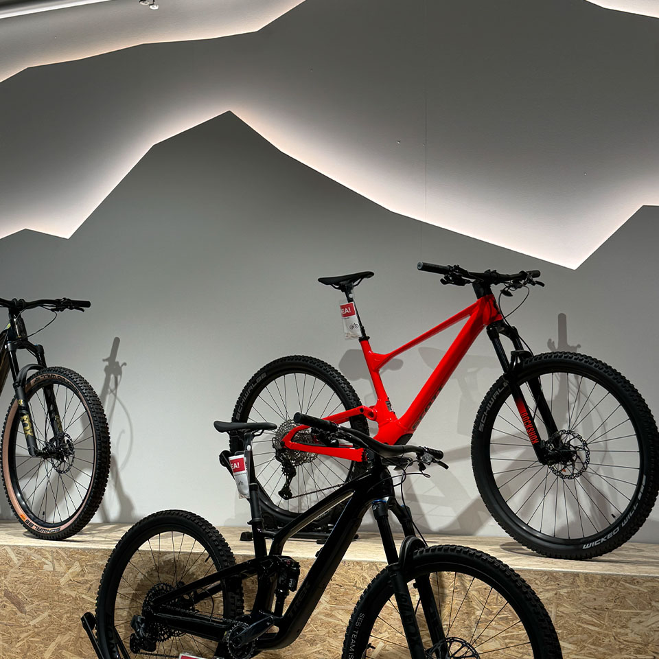 Fotografi på en röd och en svart mountainbike uppställda i cykelbutiken